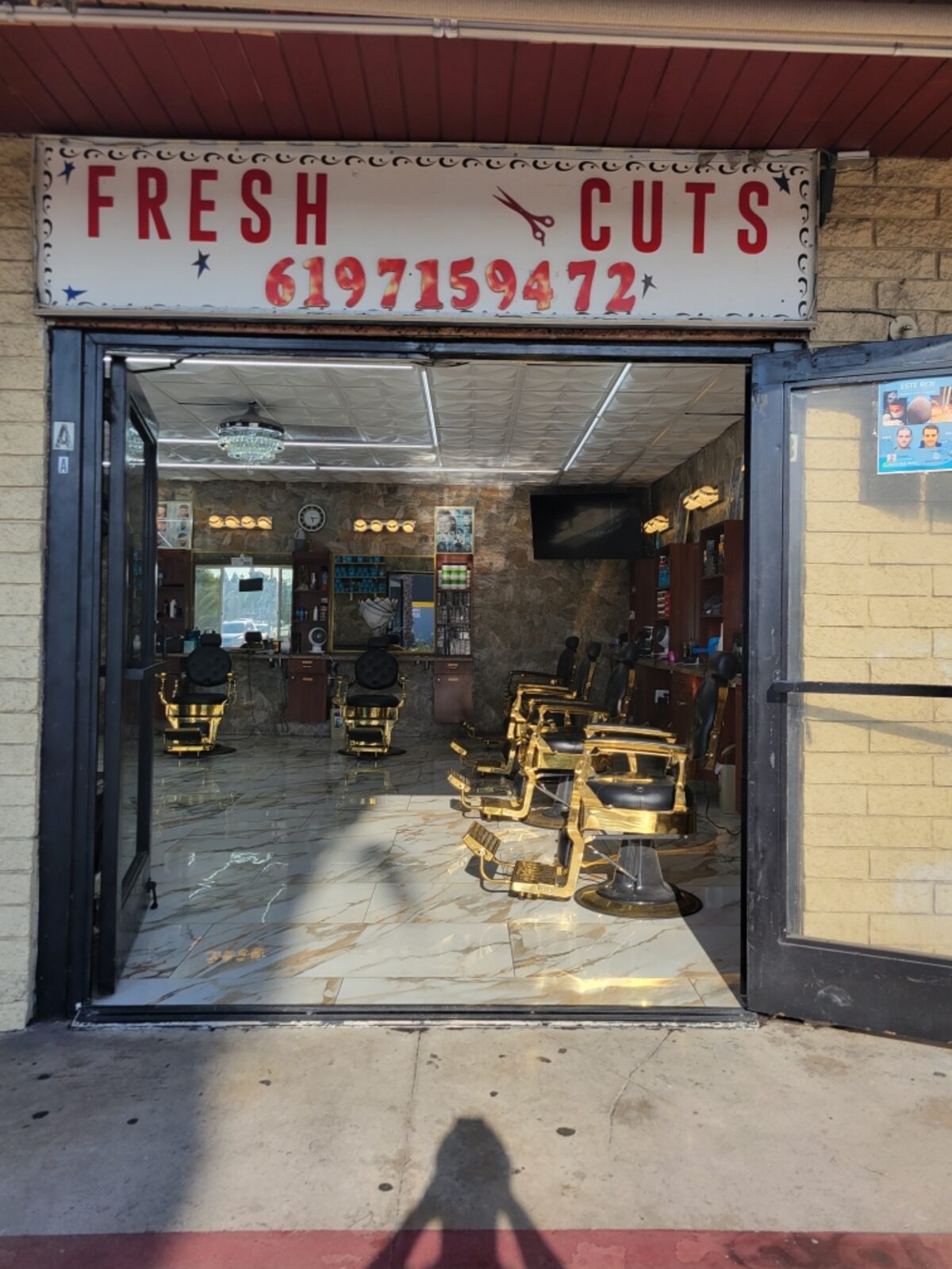 The hand-painted FRESH CUTS sign, with a scissor glyph and navy stars, over the shop door on East Main Street in El Cajon